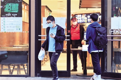 4月17日，记者在西安市南稍门附近的部分餐饮店外看到，餐馆的门口都用餐桌设置了隔档，一些顾客正在取餐。 本报记者 王晓峰 摄